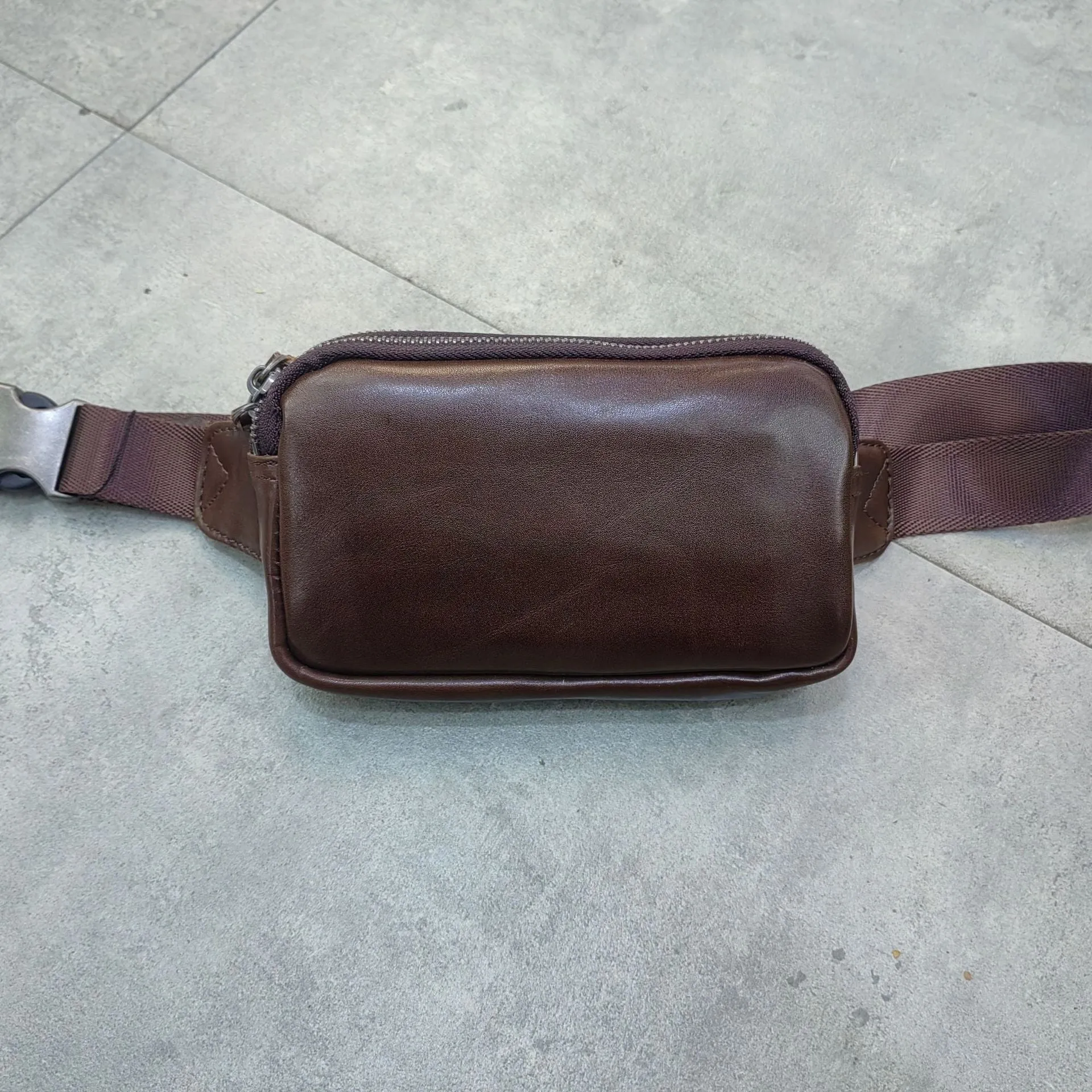 Small black cowhide leather crossbody bag for men with nylon lining.