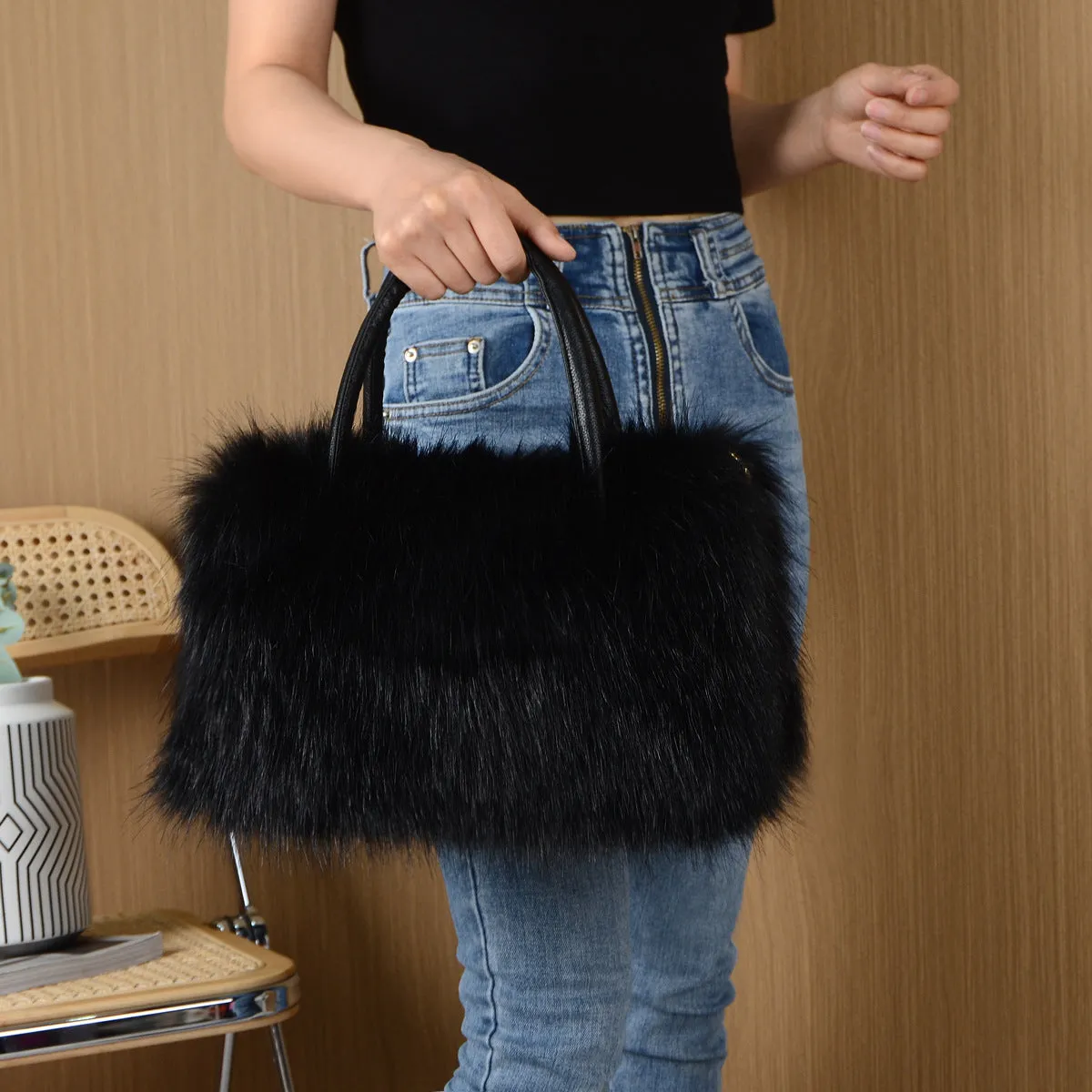 Hand-carrying square plush bag in pink with soft faux fur exterior and horizontal shape