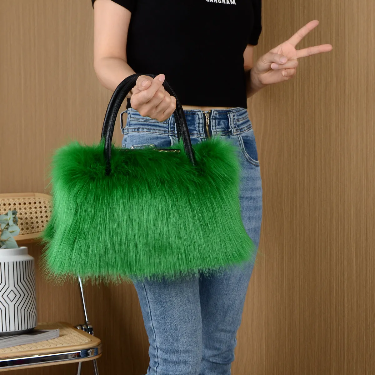 Hand-carrying square plush bag in pink with soft faux fur exterior and horizontal shape