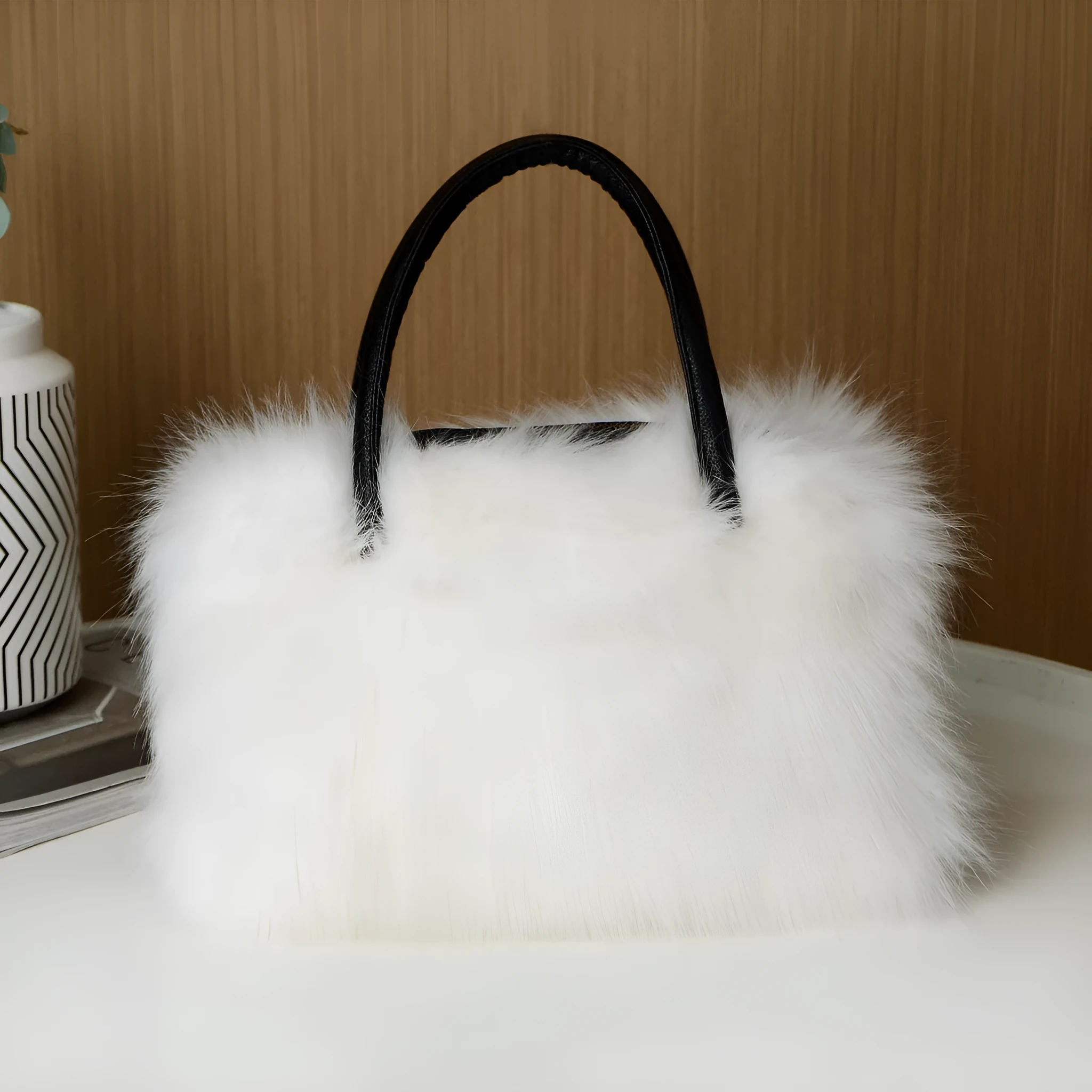 Hand-carrying square plush bag in pink with soft faux fur exterior and horizontal shape