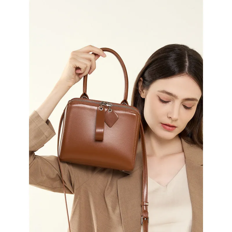 Open grain leather handbag in black with visible grain texture and welt pocket on front