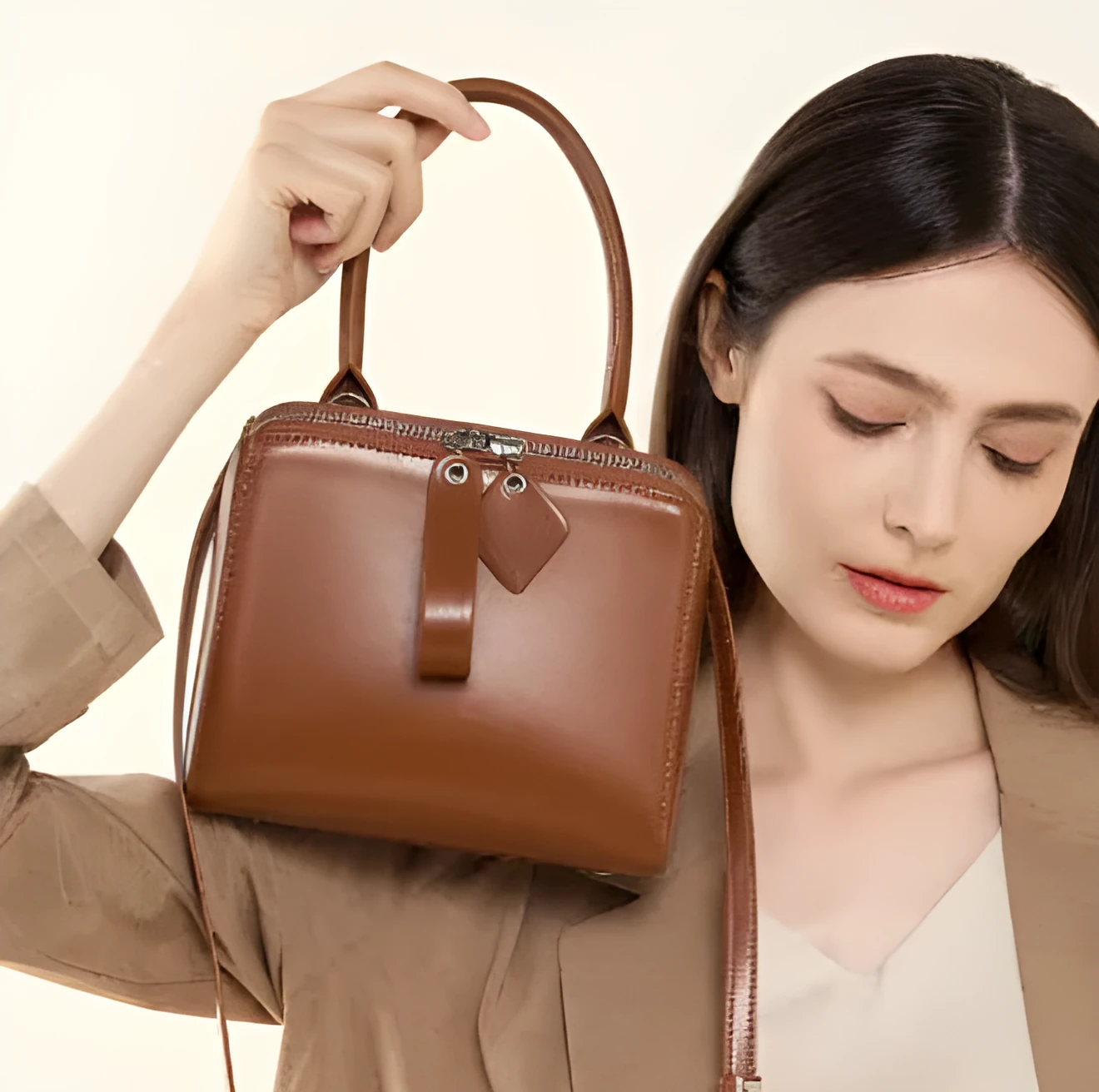 Open grain leather handbag in black with visible grain texture and welt pocket on front