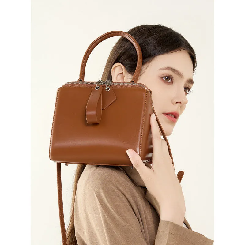 Open grain leather handbag in black with visible grain texture and welt pocket on front