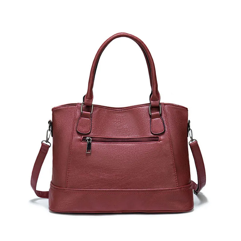 Women's PU leather handbag in black, horizontal square shape, with crossbody strap and sewing line detail