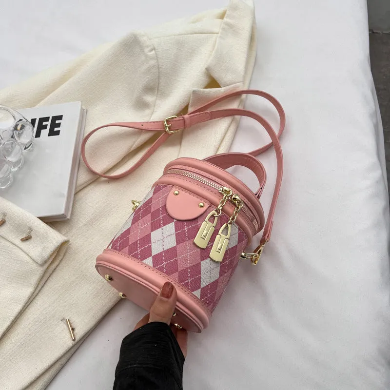 Textured rhombus cylindrical PU bucket bag in beige with white rabbit pendant, 14 cm wide.