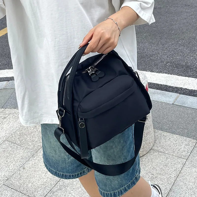 Vegan leather crossbody bag in black with double-stitched contrast thread, YKK zippers, and reinforced base