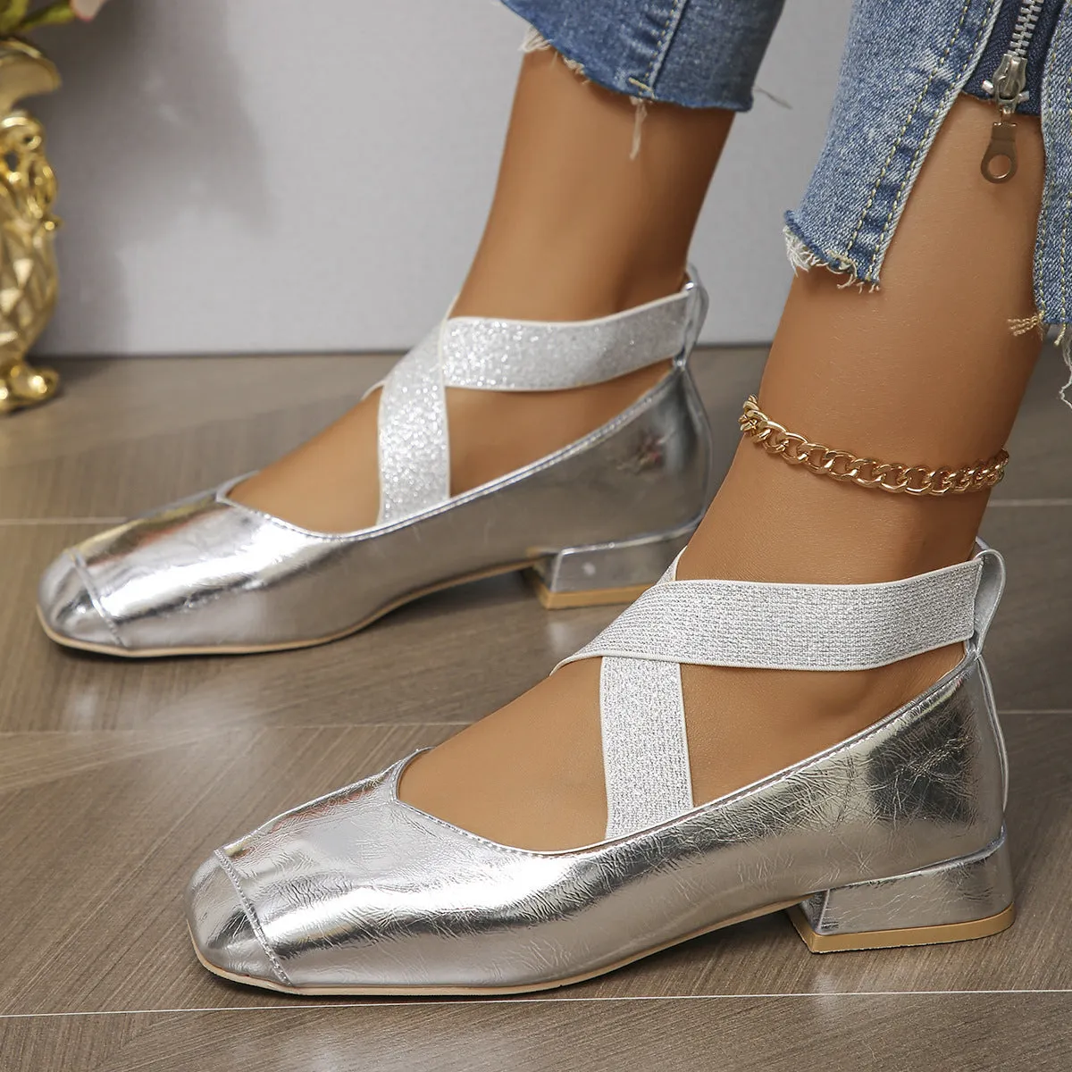 Gold French style slip-on evening pumps with square toe and low heel on a white background