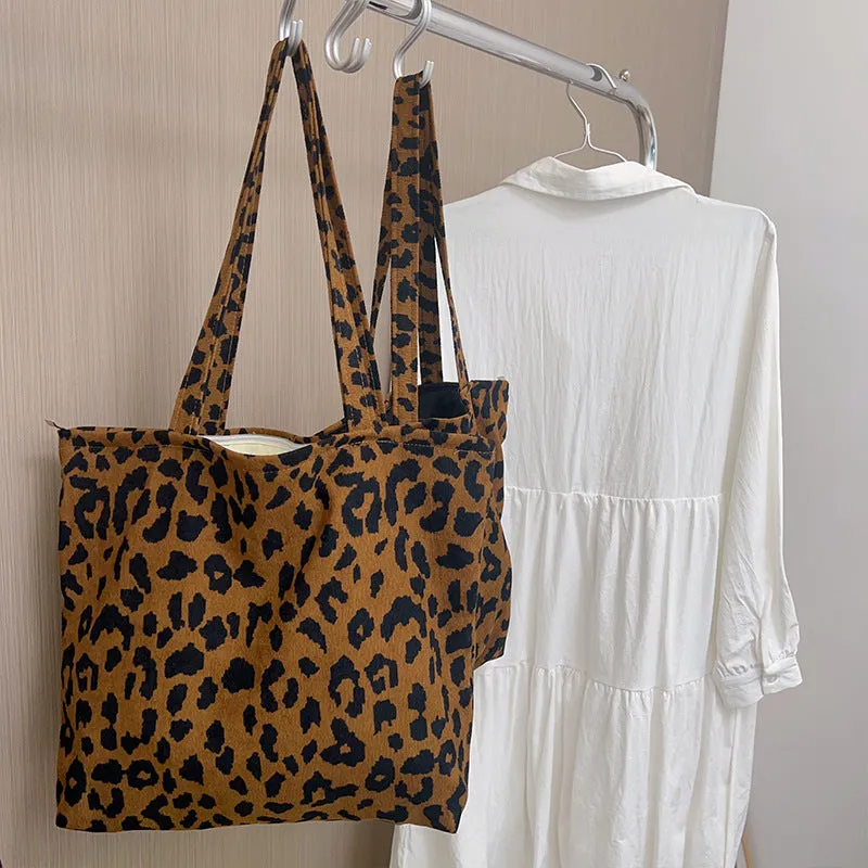 Length adjustable canvas shoulder bag in vintage leopard print with zipper closure