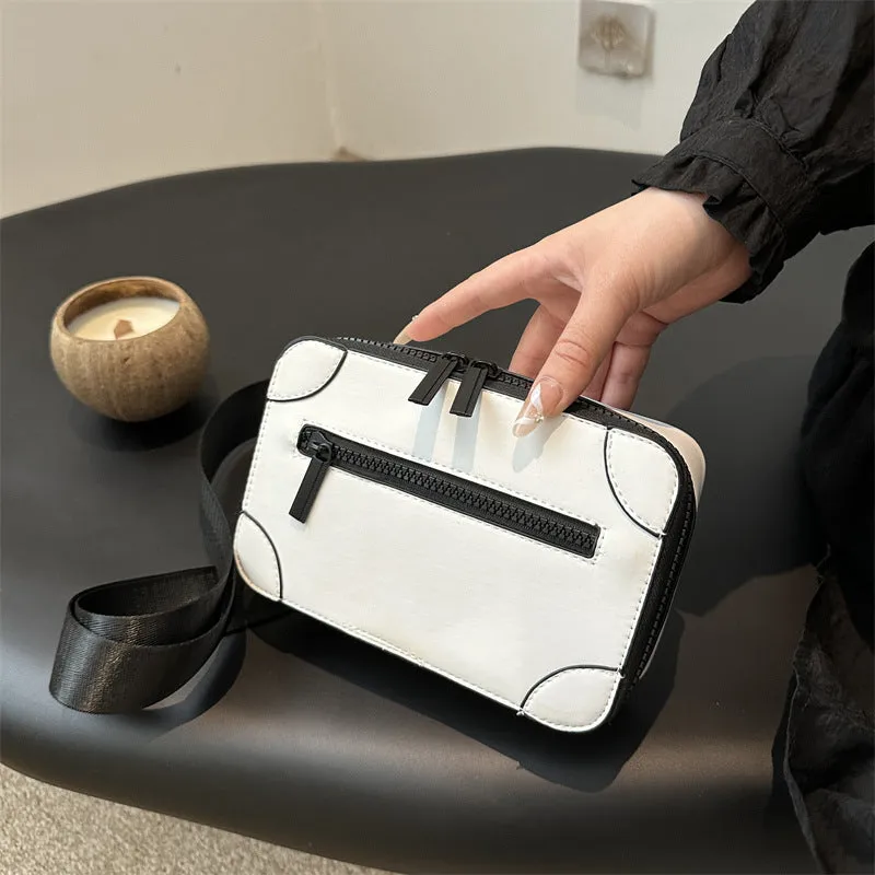 Women's black square crossbody bag showing internal mobile phone pocket and adjustable shoulder strap