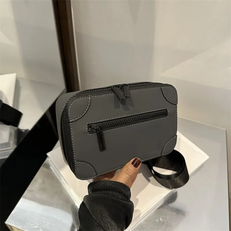 Women's black square crossbody bag showing internal mobile phone pocket and adjustable shoulder strap