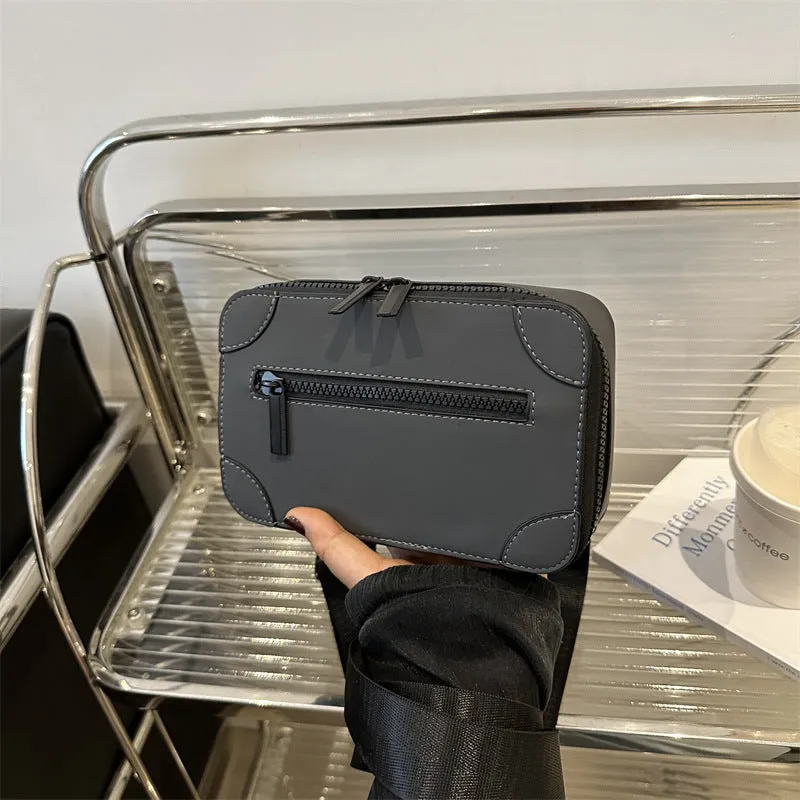 Women's black square crossbody bag showing internal mobile phone pocket and adjustable shoulder strap