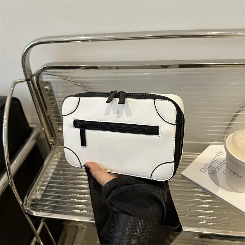 Women's black square crossbody bag showing internal mobile phone pocket and adjustable shoulder strap