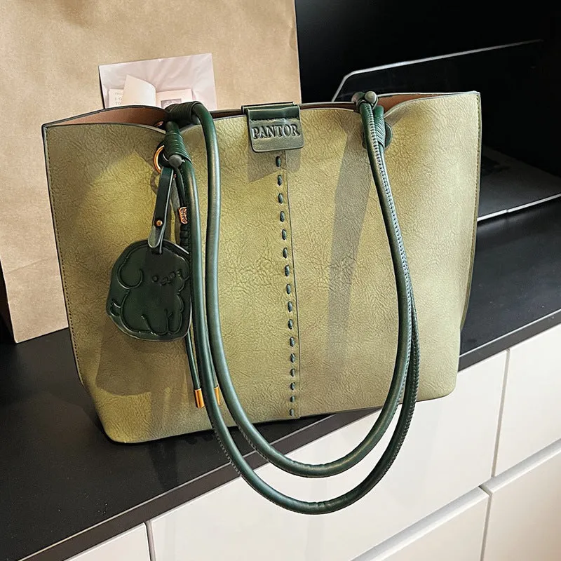 Green urban minimalist PU shoulder bag with stitching detail and double straps on a white background.