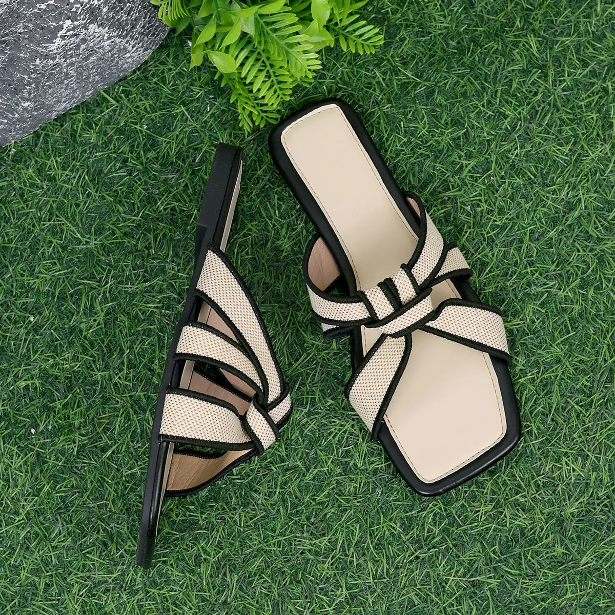 Women's half slippers with artificial PU upper and non-slip rubber sole in black and milky white on a light background