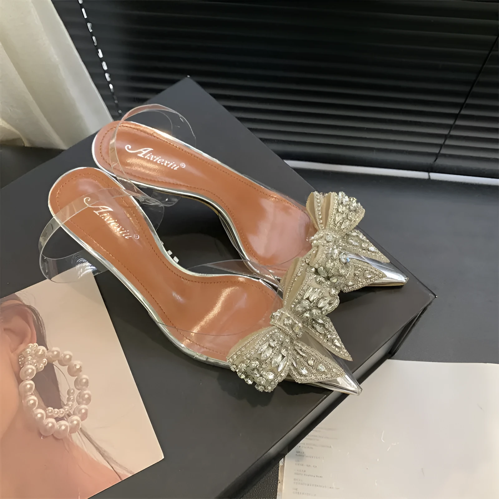 Silver women's bow rhinestone pointed transparent high heel sandals on display