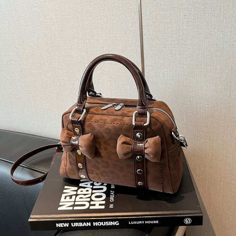 Soft PU pillow bag with crossbody strap, stitching, rivets, and leopard print in brown with pendant