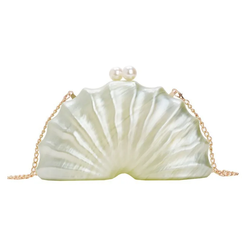 Acrylic shell-shaped clutch bag in champagne with silver chain on white background