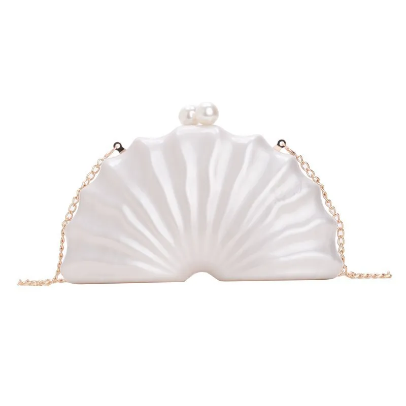 Acrylic shell-shaped clutch bag in champagne with silver chain on white background