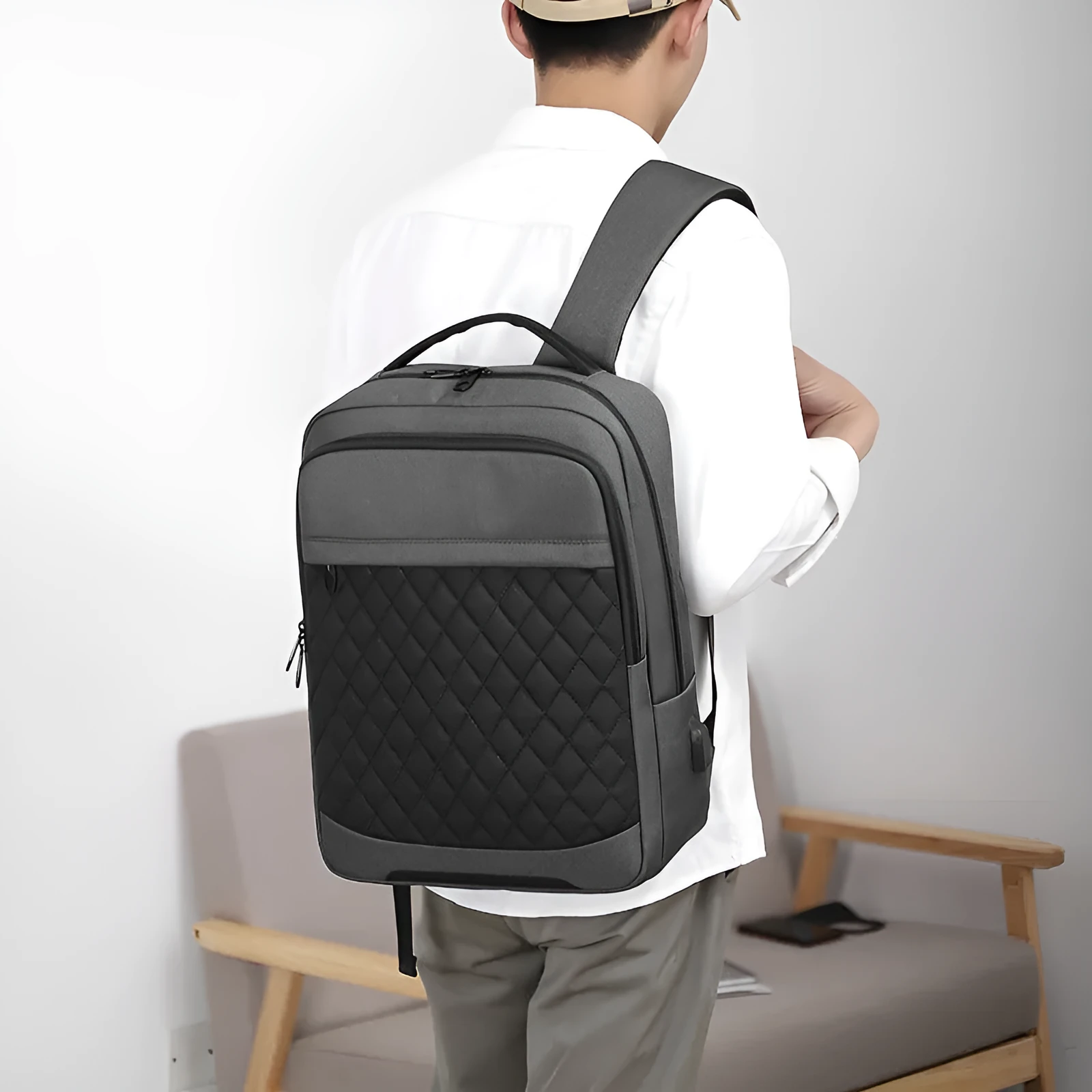 Men's solid colour Oxford cloth travel backpack with curved shoulder strap shown in black, blue, and grey.