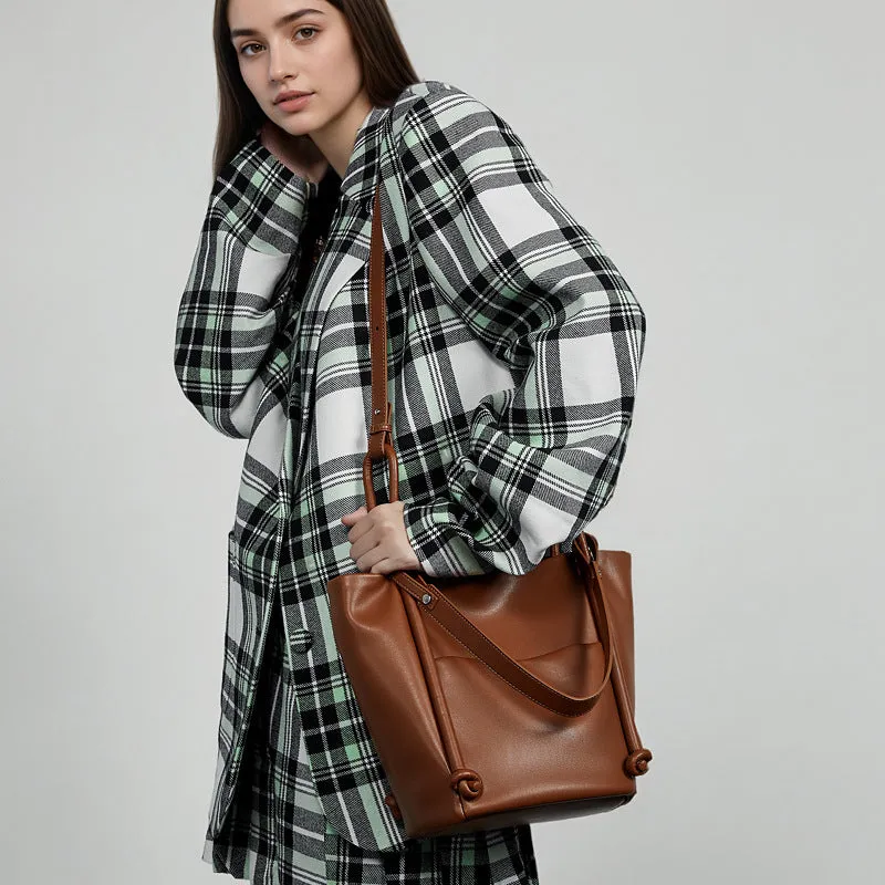 Soft cowhide genuine leather bucket tote bag in black with crossbody strap, 26cm height, urban minimalist design