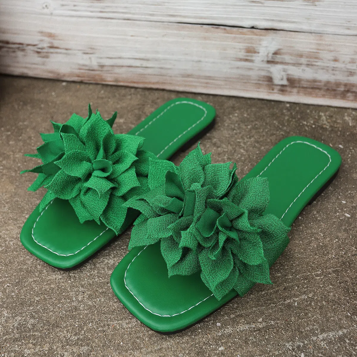 Flat flip-flops with flower decoration in faux leather and rubber sole in black colour for women