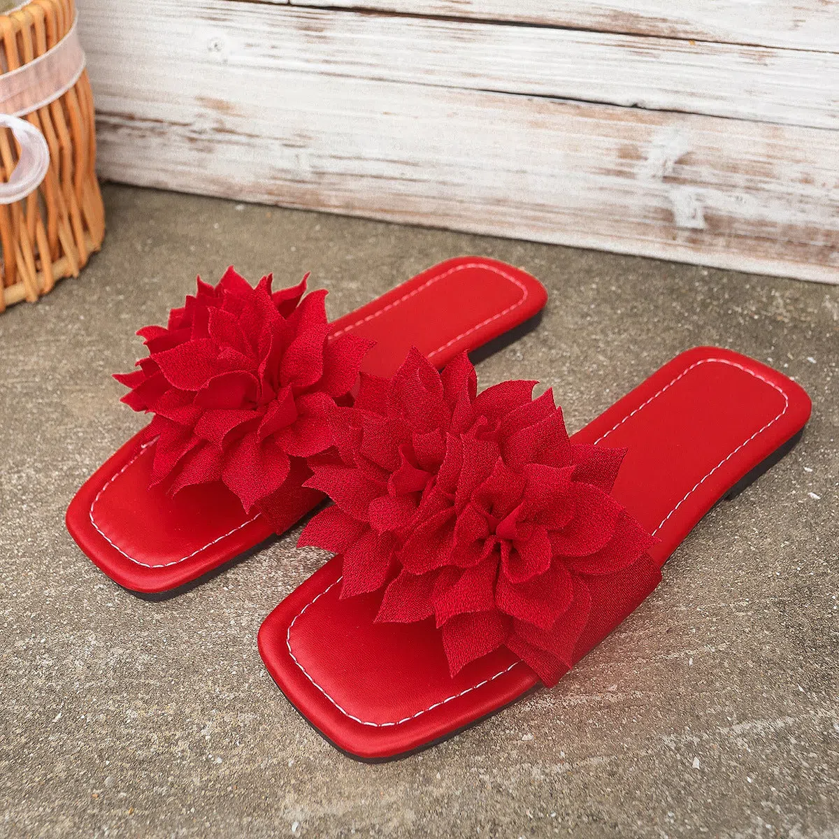 Flat flip-flops with flower decoration in faux leather and rubber sole in black colour for women