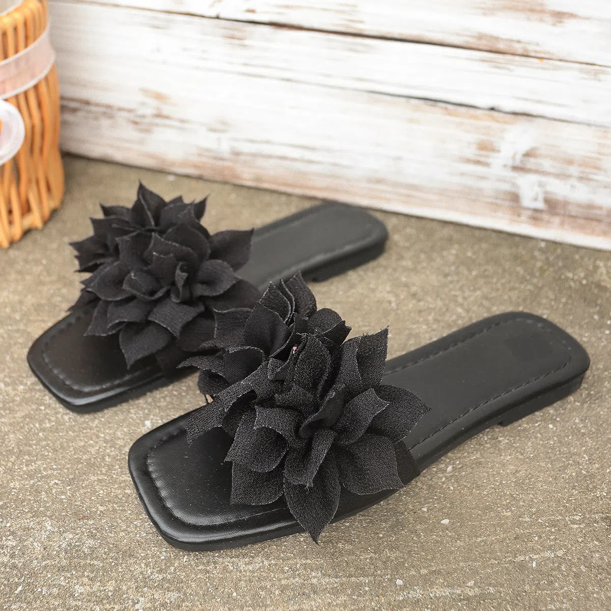 Flat flip-flops with flower decoration in faux leather and rubber sole in black colour for women