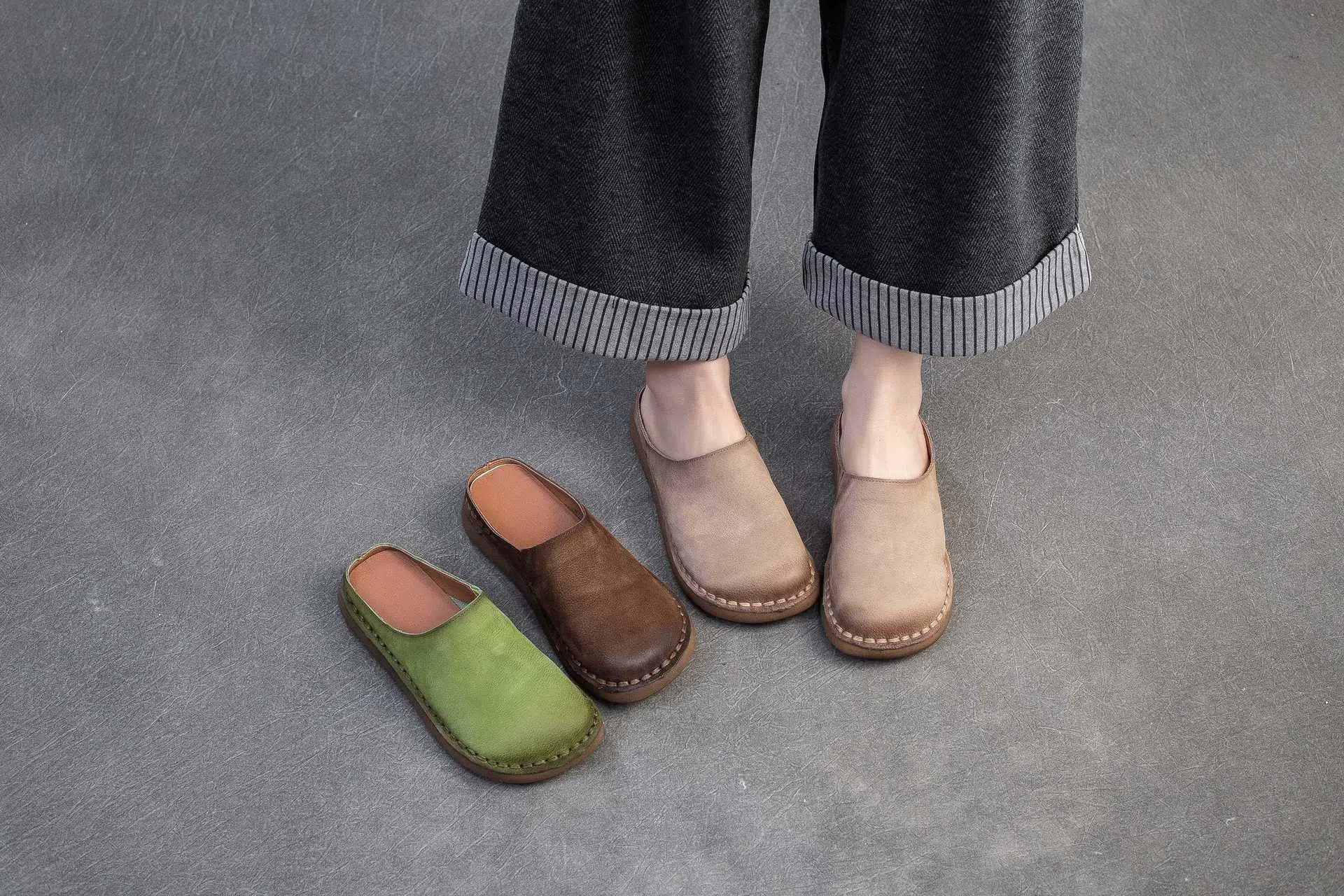 Genuine leather retro wrap-around lazy slippers in brown colour with rubber sole on a neutral background
