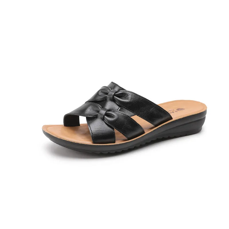 Beige cowhide leather slippers with a soft sole, shown from the side.