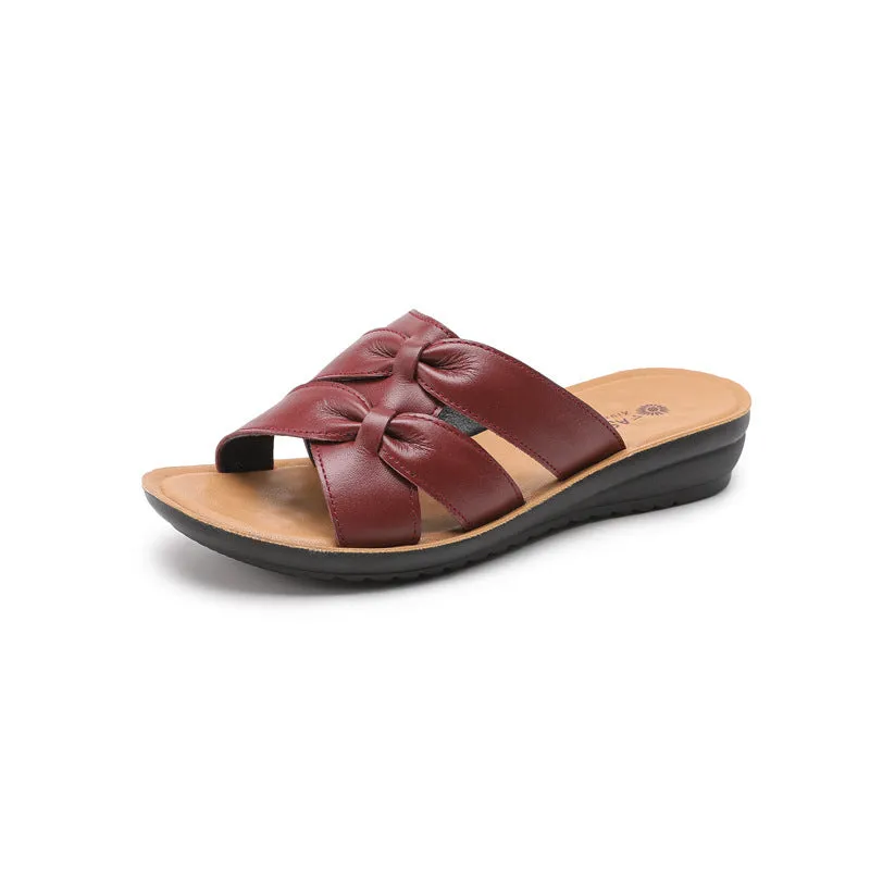 Beige cowhide leather slippers with a soft sole, shown from the side.