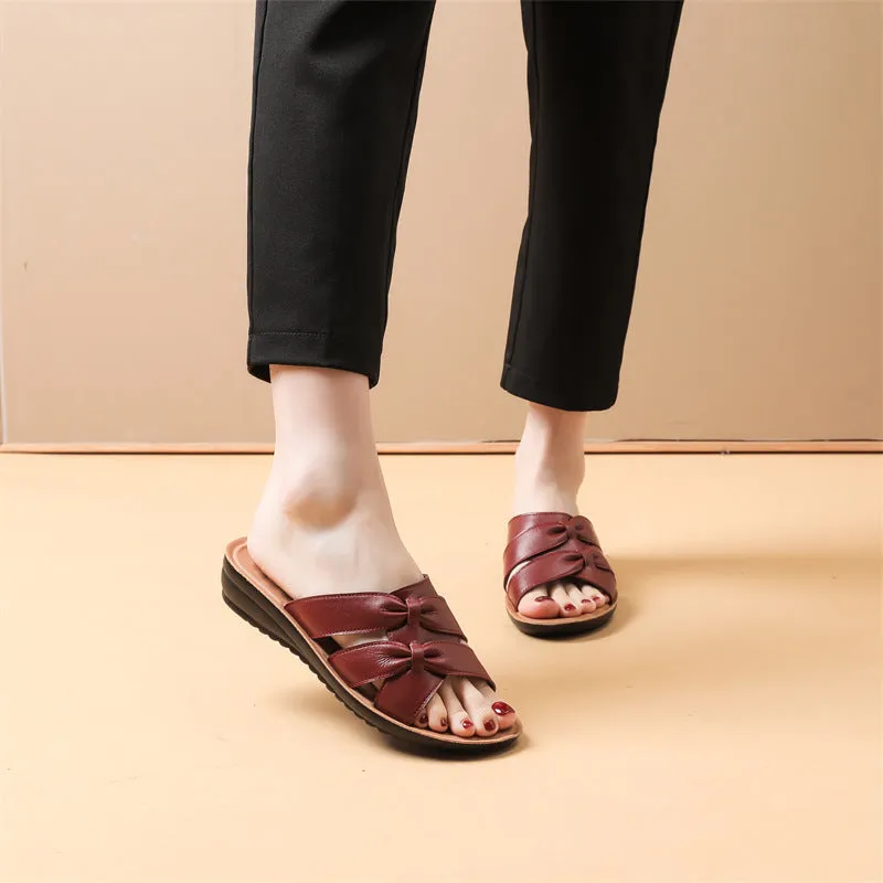 Beige cowhide leather slippers with a soft sole, shown from the side.