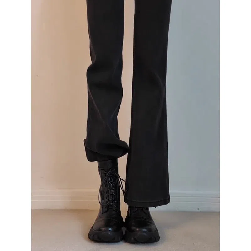 Black thick-soled motorcycle boots with back zipper and lace-up closure on a grey background
