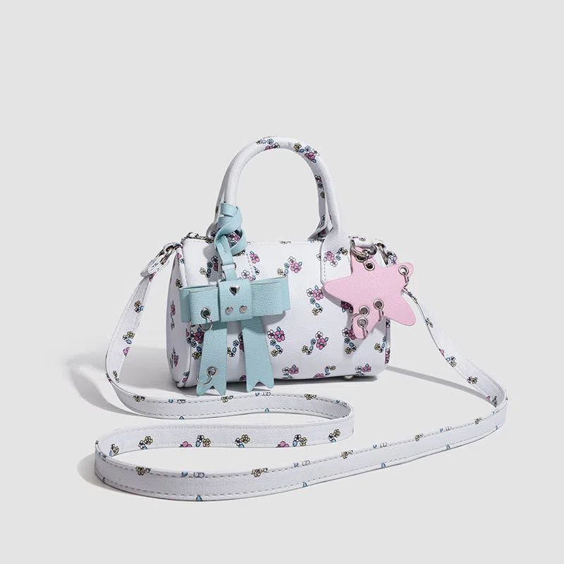 White PU hand-held shoulder bag with petite floral bow accessory on display
