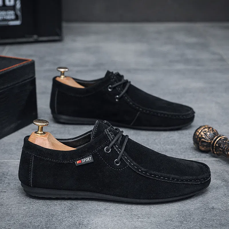 Men's black slip-on loafers with soft sole, round toe, and stitching detail on a neutral background