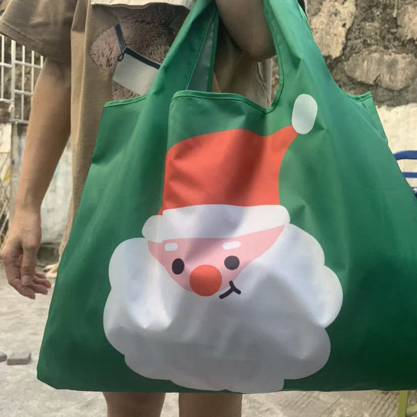 Large one-shoulder polyester Santa Claus gift bag with festive red and white design