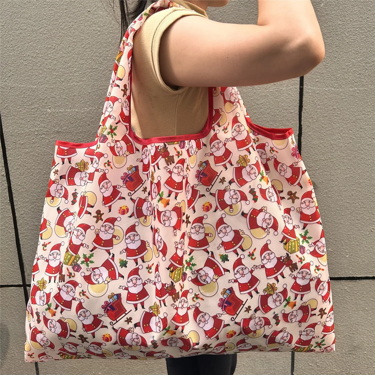 Large one-shoulder polyester Santa Claus gift bag with festive red and white design