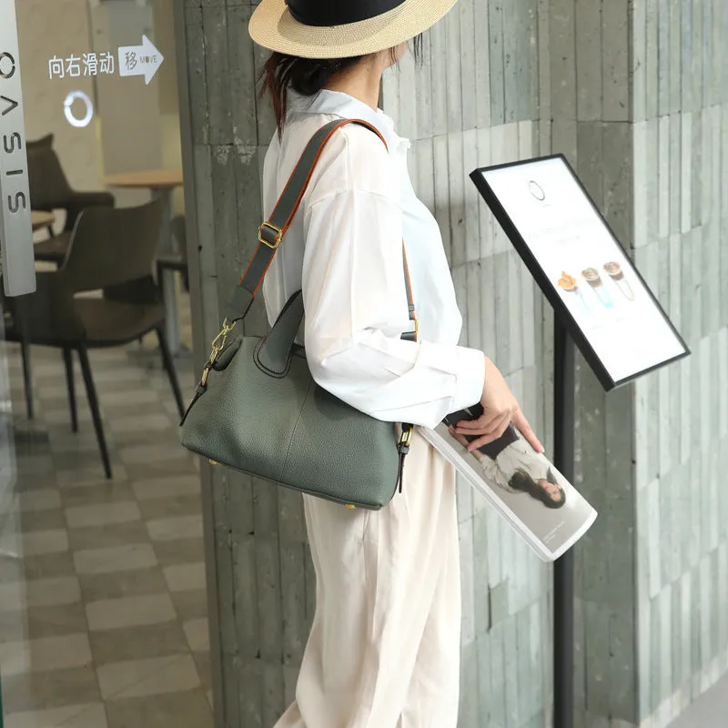 Women's leather cross-body bag in horizontal square shape with visible sewing thread detailing and interior compartments
