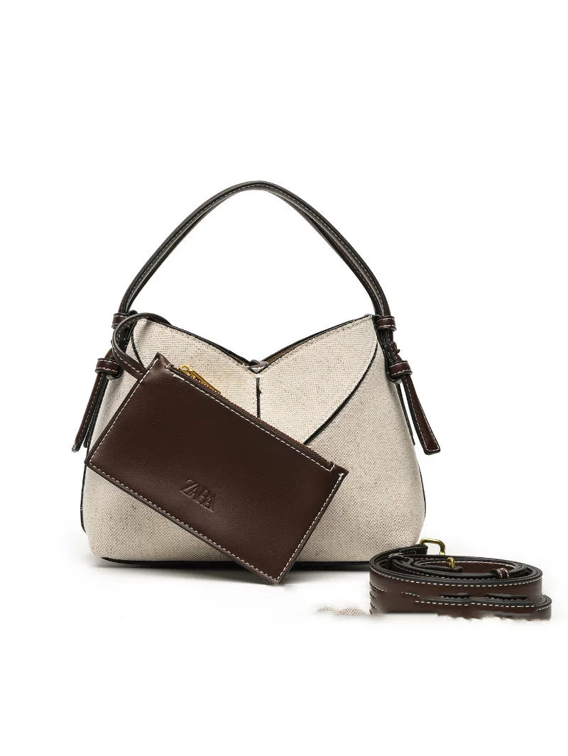 Trendy solid colour stitched oval handbag and crossbody bag for women in black with single shoulder strap and interior slip pocket