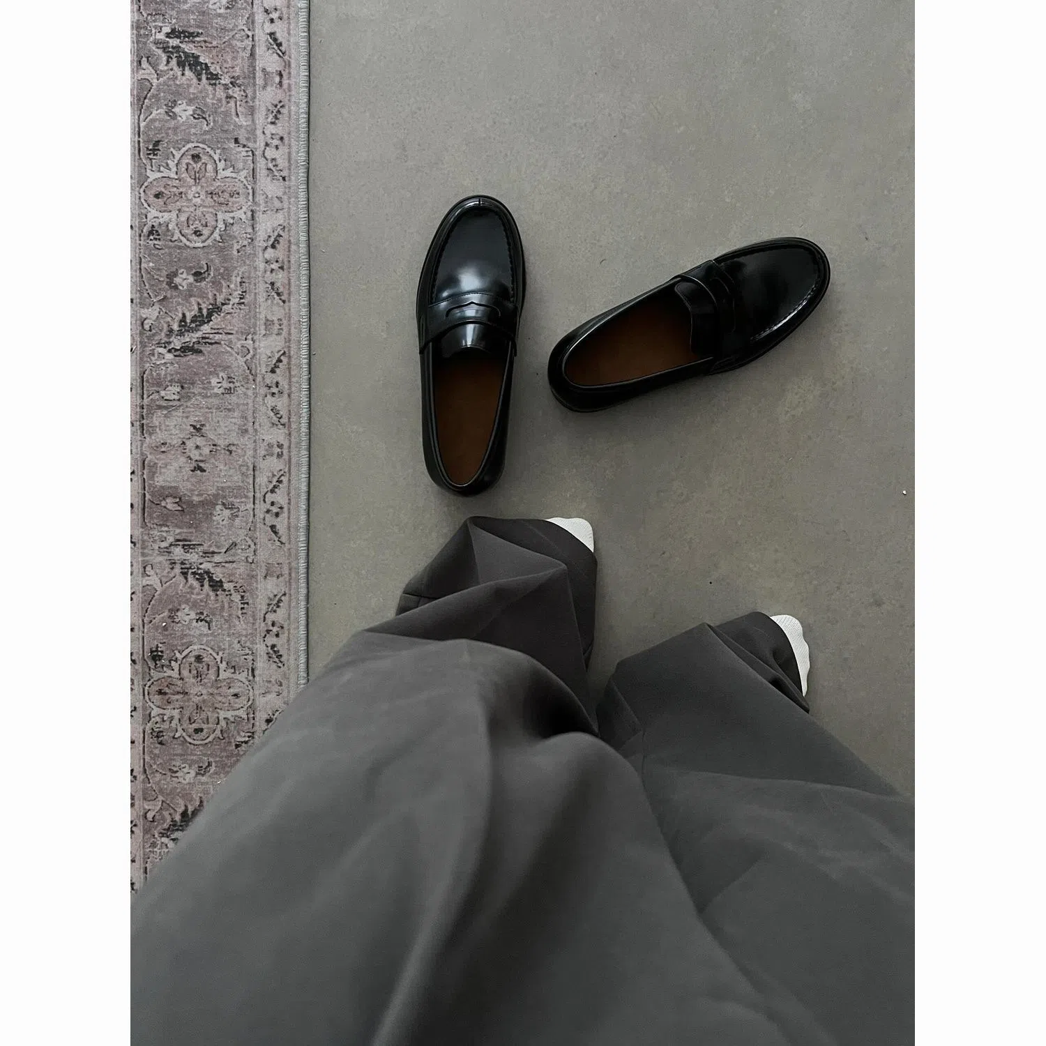 Men's black leather loafers with stitched seams, square heel, and vulcanised rubber sole on display
