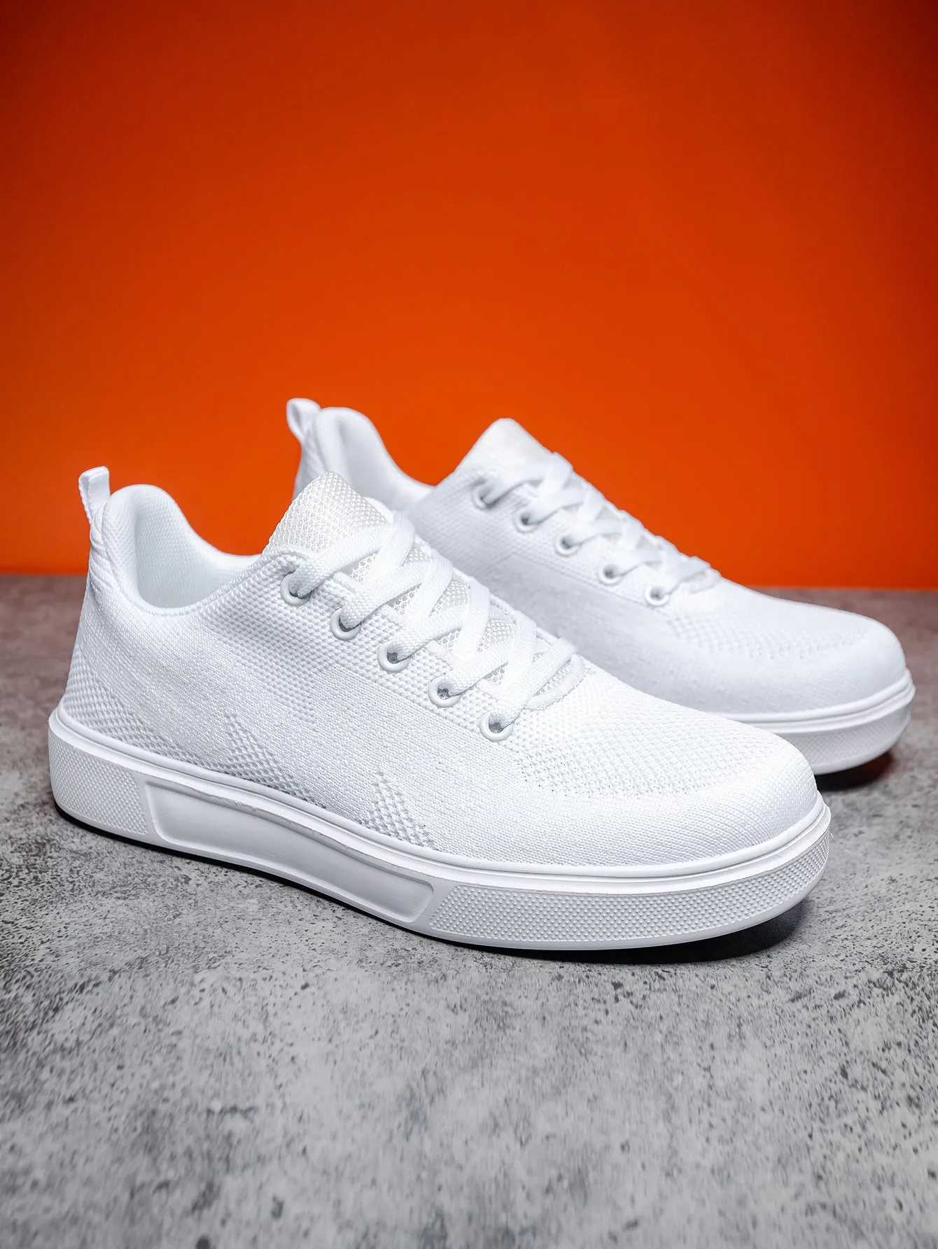 White casual sports shoes with thick EVA sole and mesh upper, flat heel, round toe, front lace-up closure