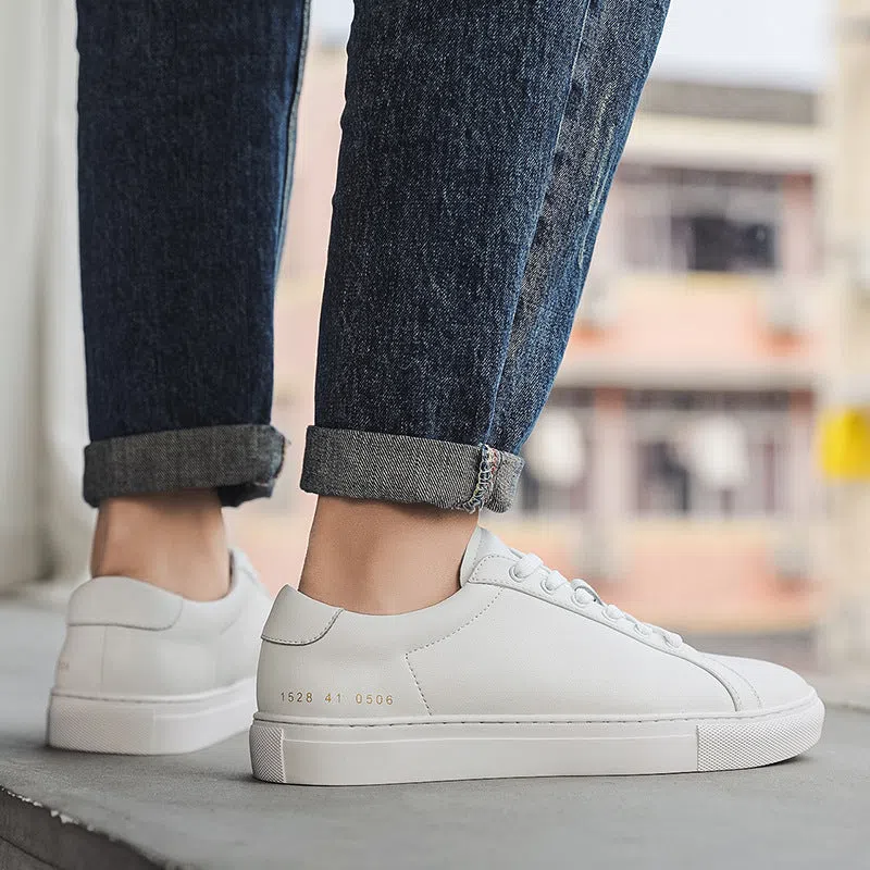 White flat-soled cowhide sneakers with stitching detail and round toe