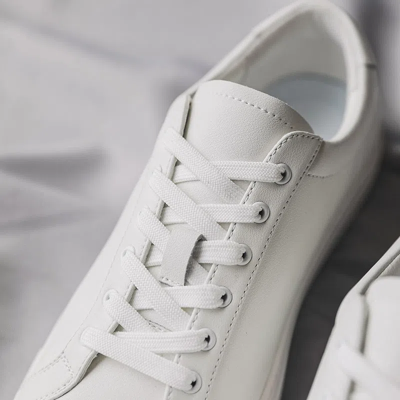 White flat-soled cowhide sneakers with stitching detail and round toe