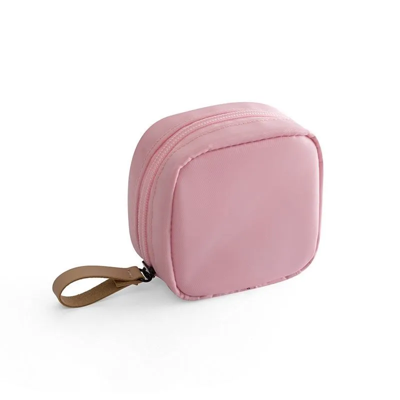 Blue cloth cube-shaped makeup storage bag on a table.
