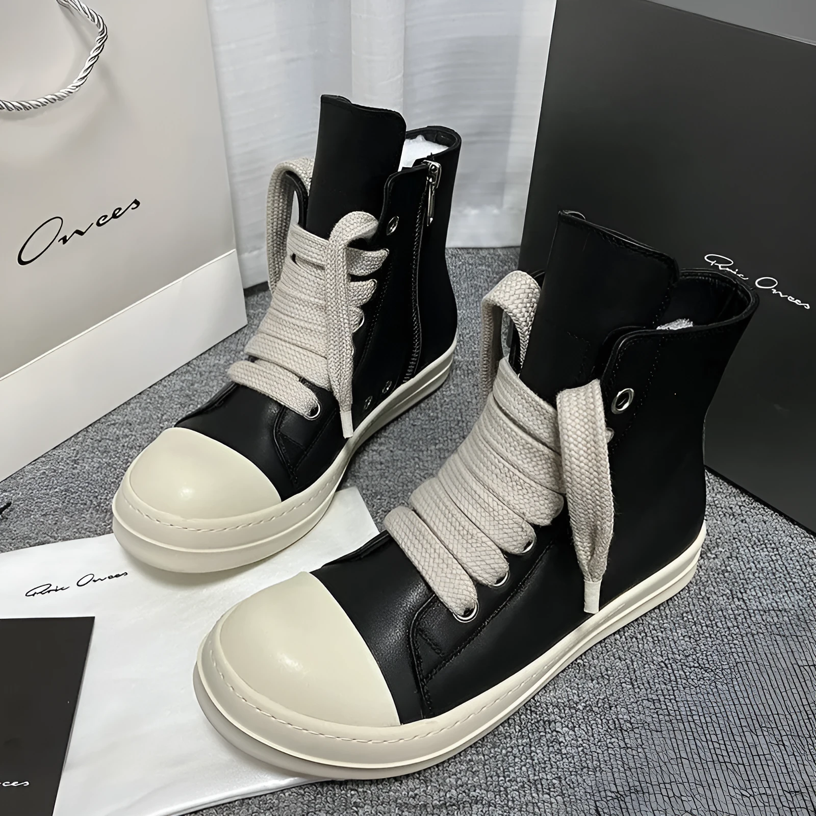 Black leather high-top sneakers with side zipper and round toe on a rubber platform sole