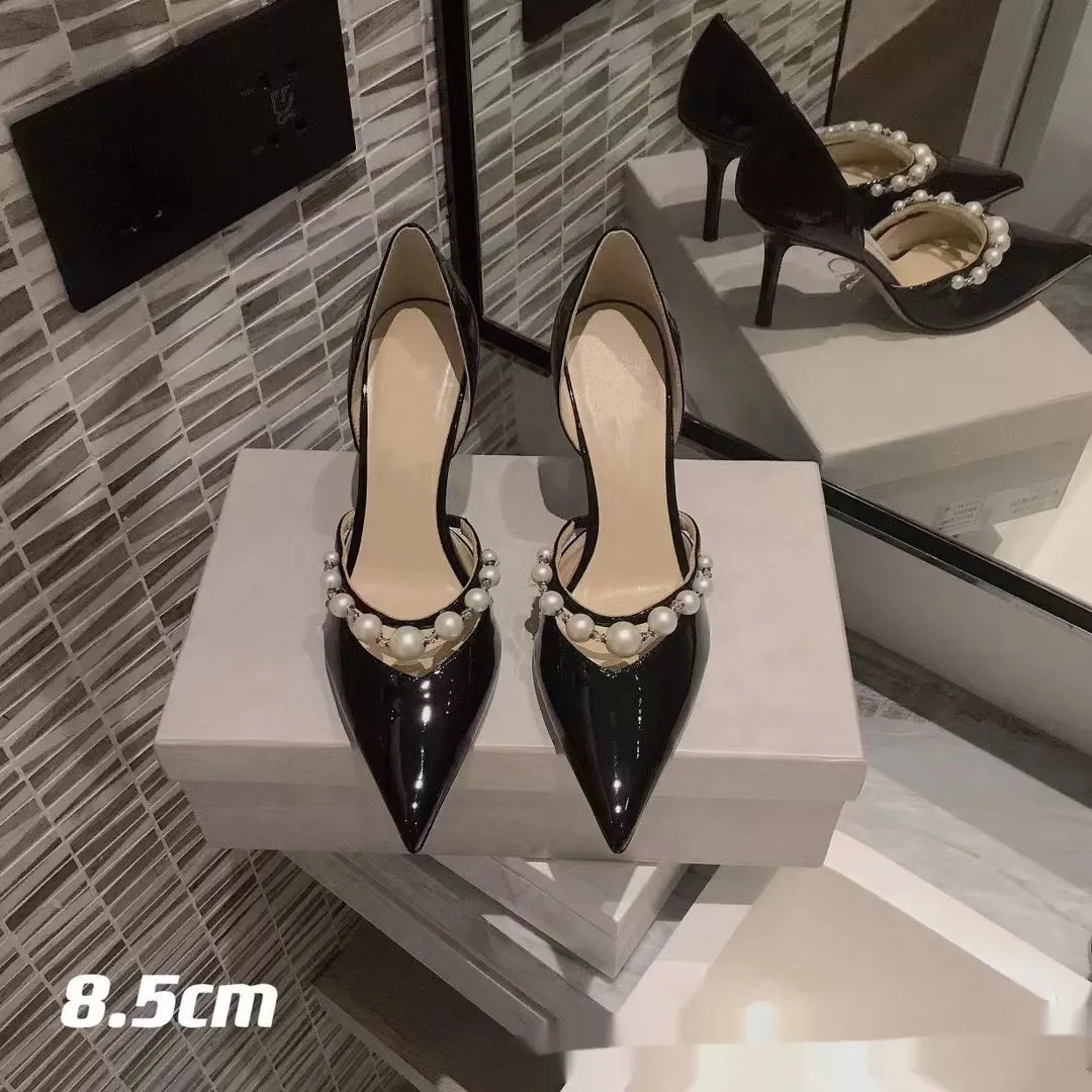 Black pointed toe patent leather women's stiletto heels with pearl decoration on the heel.