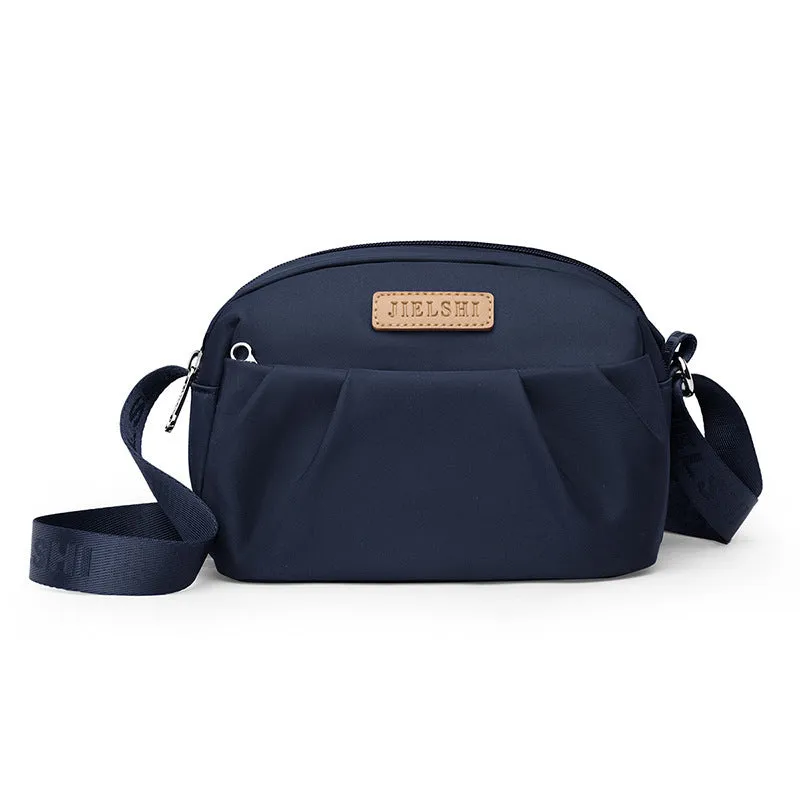 Pleated Oxford cloth crossbody messenger bag in a horizontal square shape with a phone compartment.