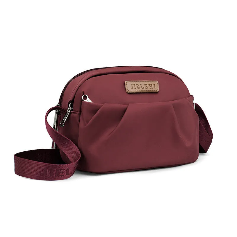Pleated Oxford cloth crossbody messenger bag in a horizontal square shape with a phone compartment.