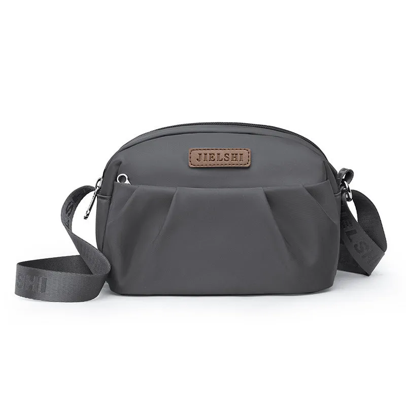 Pleated Oxford cloth crossbody messenger bag in a horizontal square shape with a phone compartment.