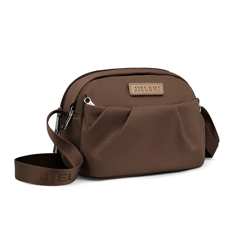 Pleated Oxford cloth crossbody messenger bag in a horizontal square shape with a phone compartment.