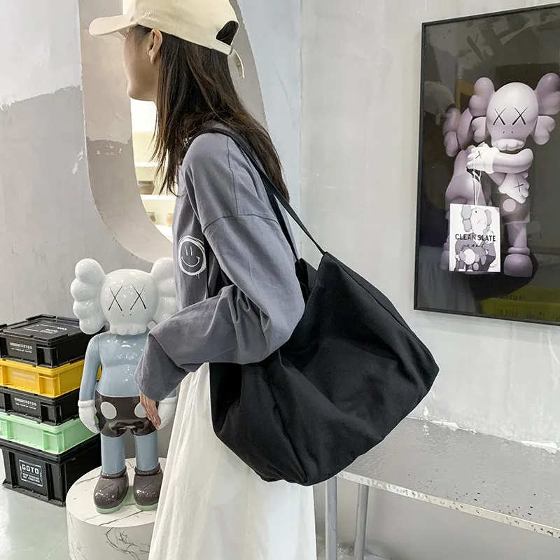 Women's black canvas shopping handbag with double shoulder straps showing internal mobile phone pocket